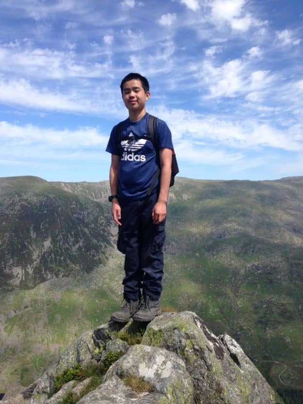 An image of Joshua standing on the top of a small mountain